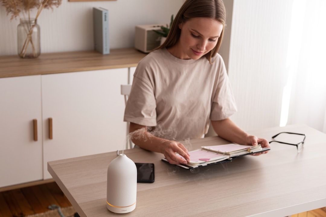 a woman sitting at a table looking at a book