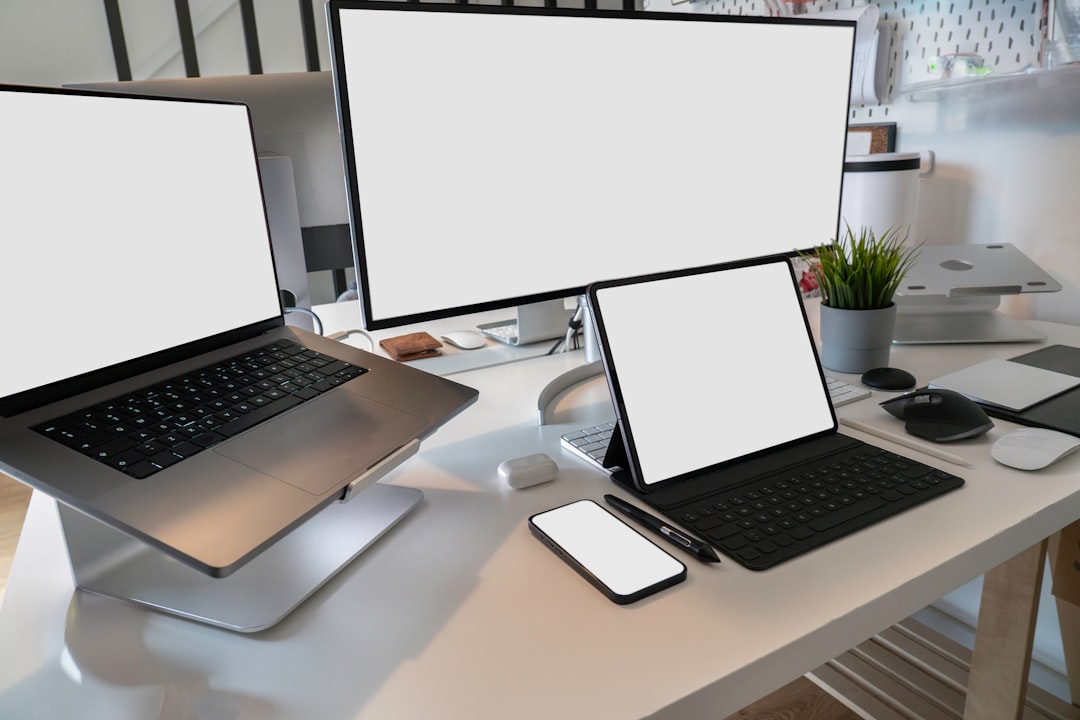 a desk with two laptops and a phone on it