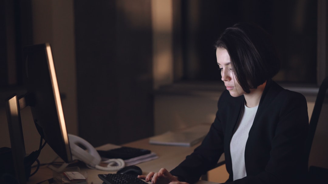 Woman working late at a computer in an office.