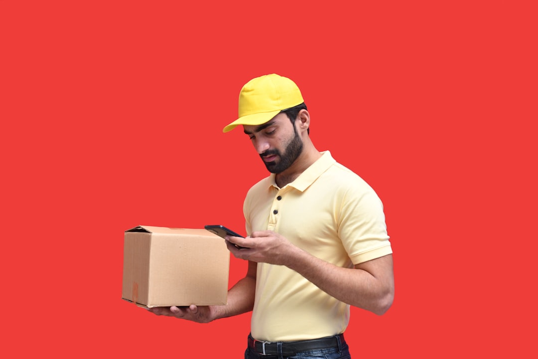 a man in a yellow hat looking at a phone