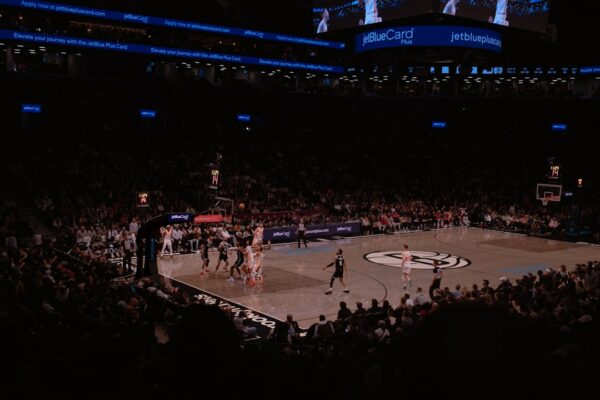 Basketball game in a crowded arena at night stadium.