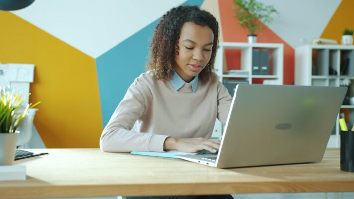 Woman typing on a laptop at a desk.