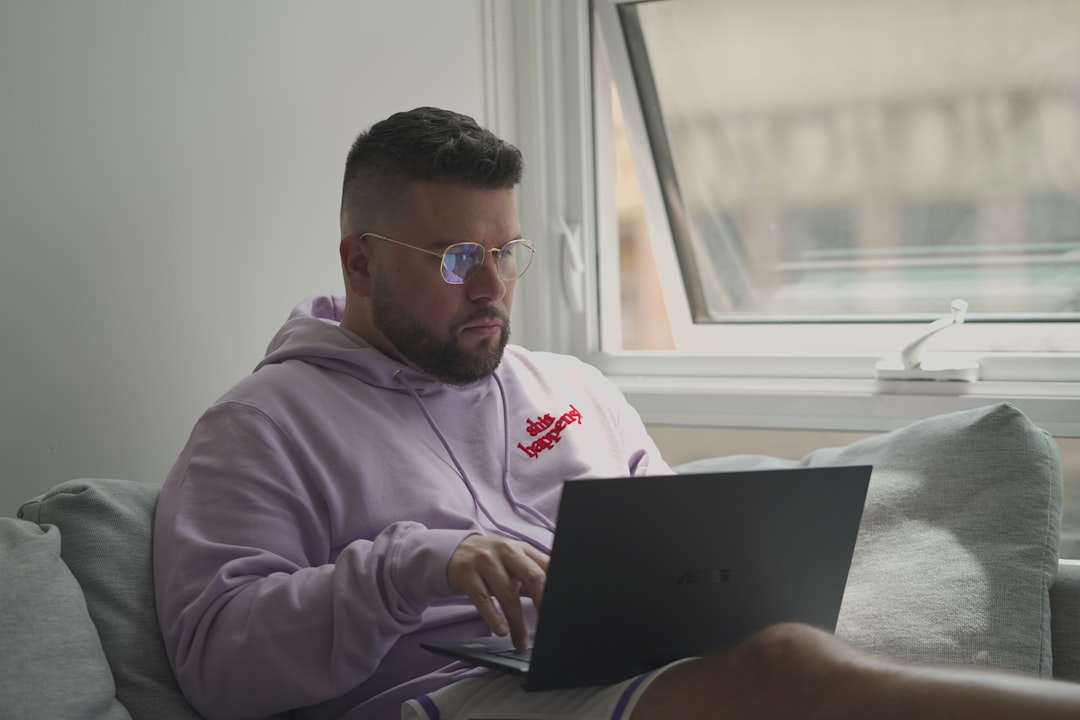 man in pink hoodie using macbook