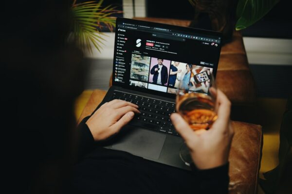 A person sitting on a couch with a laptop