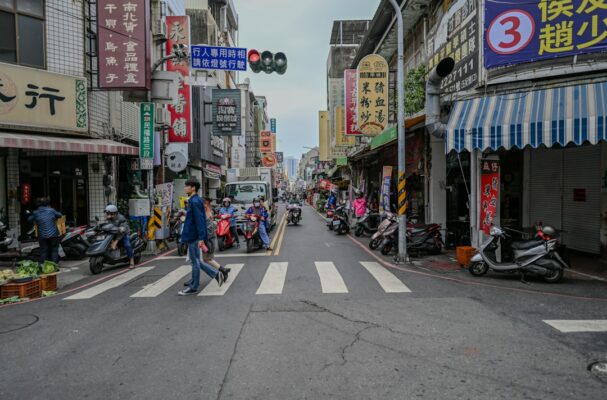 A man walking across a cross walk in a city