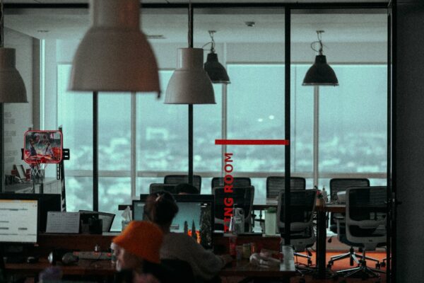 a group of people sitting at a desk with a large window
