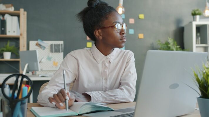 Young woman working at a desk with laptop.
