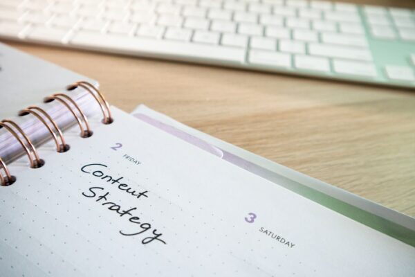 a notepad with a spiral - bound notebook on it next to a keyboard